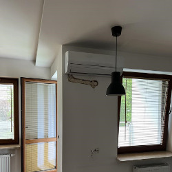 Widok klimatyzatora z instalacją prowadzoną w bruździe w ścianie (aby było poprawnie, musi być ona wyprowadzona z lewego, dolnego narożnika urządzenia)