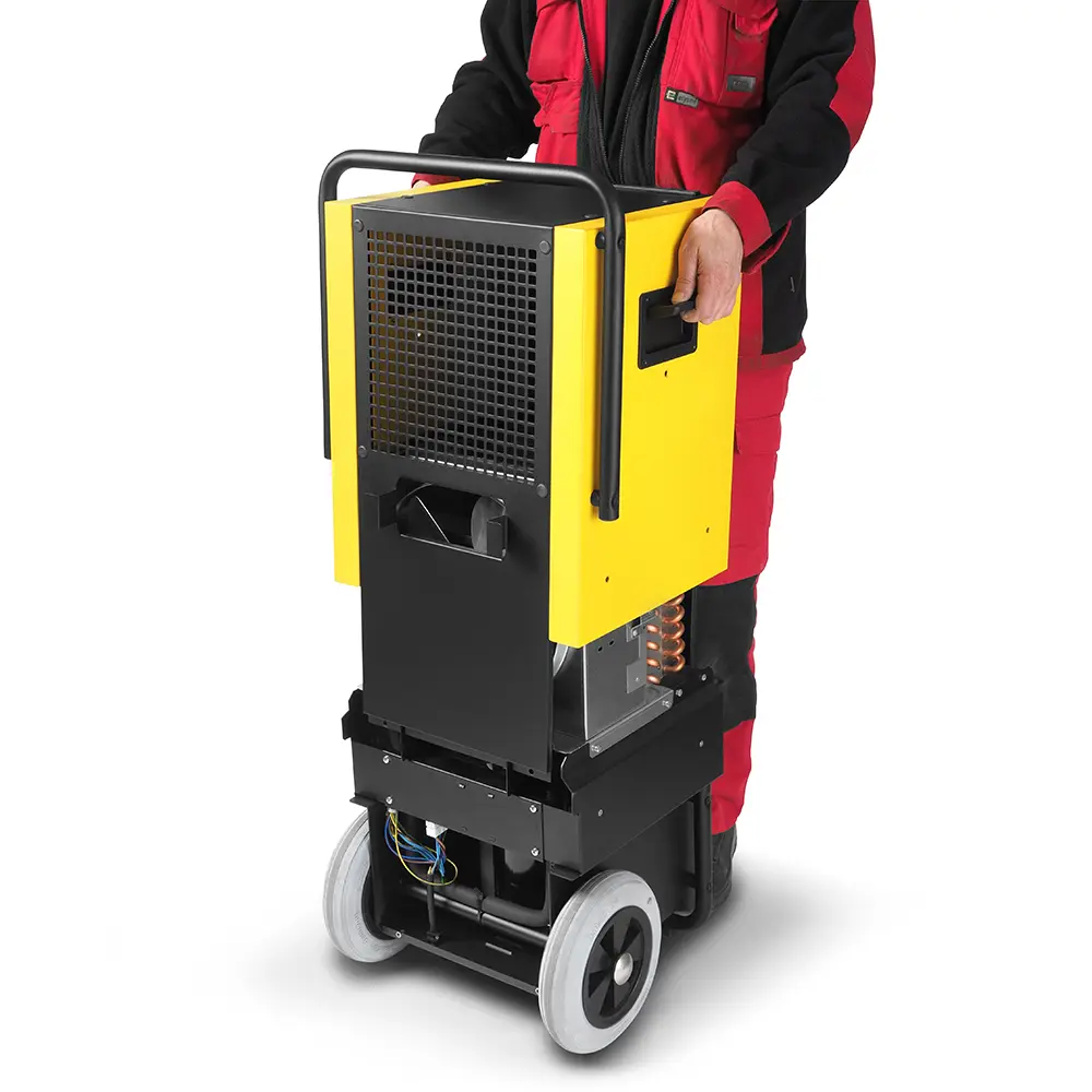 Osuszacz powietrza Trotec TTK 500 - człowiek trzymający osuszacz za uchwyty