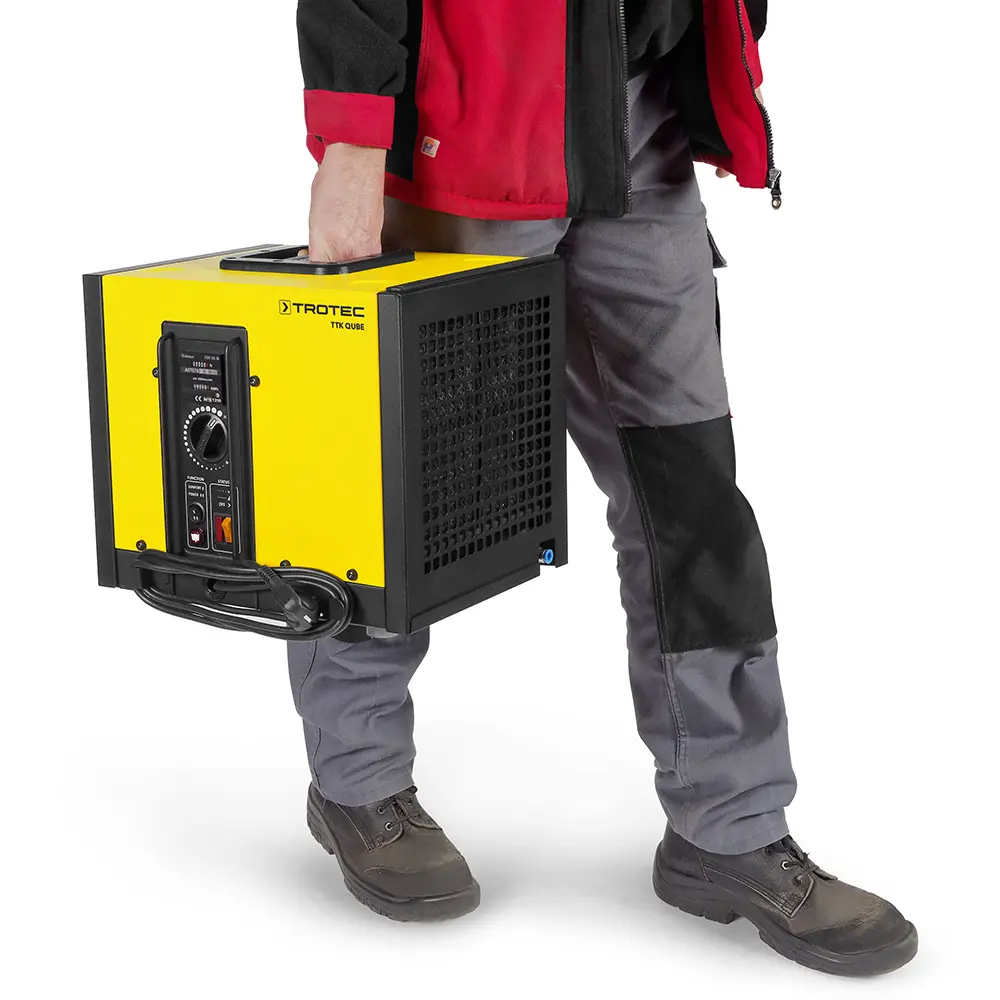 Osuszacz powietrza Trotec TTK Qube - człowiek trzymający urządzenie za uchwyt